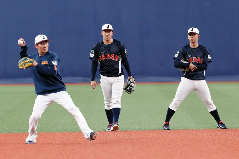 源田(左）の守備練習に熱い眼差しを注ぐ宗山（右）。中央は小園　©︎JIJI PRESS