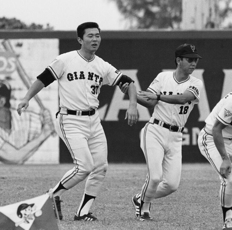 1984年、グアムでのキャンプ。堀内恒夫コーチに腕を引っ張られる江川　©JIJI PRESS