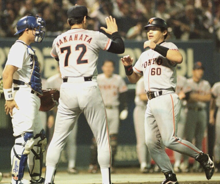 10.8決戦で先制の15号ソロを放ち、中畑清コーチに迎えられホームインする落合博満　©KYODO