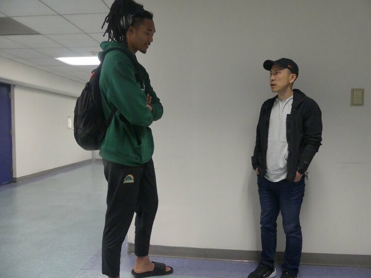 パリ五輪日本代表で、米フォーダム大学でプレーするジェイコブス晶（21歳）の視察に訪れた吉本コーチ（写真=筆者撮影）