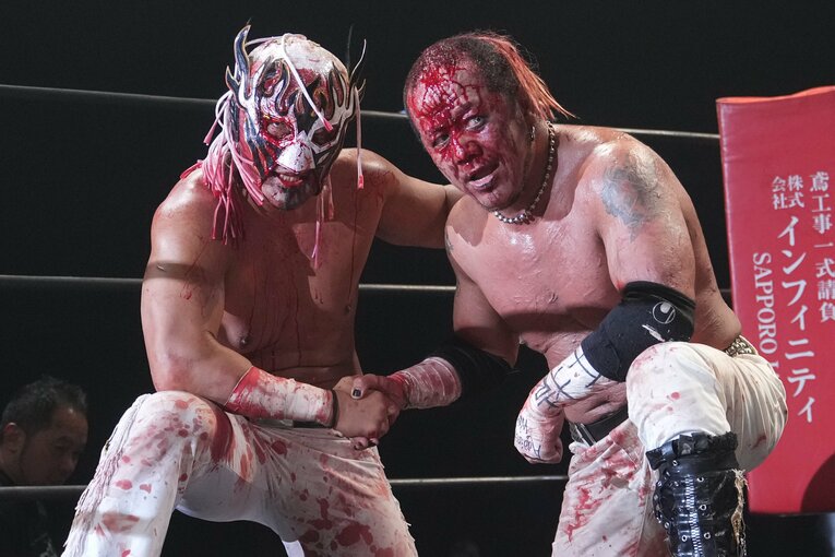 試合後、血まみれになりながら握手をかわすエル・デスペラードと葛西純