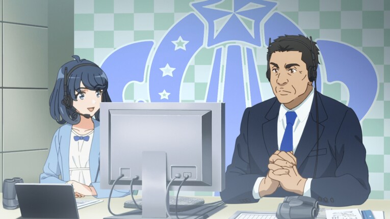 実況席。青ネクタイの引き締まった体のこの人は…　©Cygames, Inc.