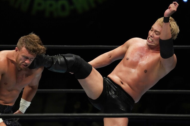 オスプレイの首にキックを入れるオカダ