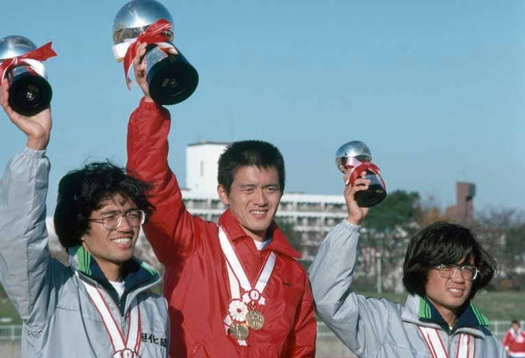 1979年の福岡国際マラソンで優勝し、表彰式でカップを手に喜ぶ瀬古利彦（中央）。左は2位の宗茂、右は3位の宗猛　©JIJI PRESS