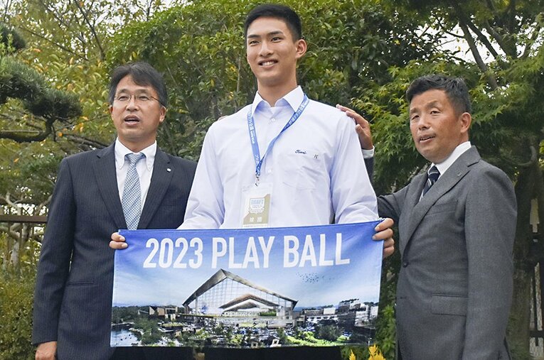 ドラフト1位指名のあいさつを受け、撮影に応じる天理高の達孝太投手と日本ハムの大渕スカウト部長（左）、熊崎誠也スカウト ／ photograph by KYODO
