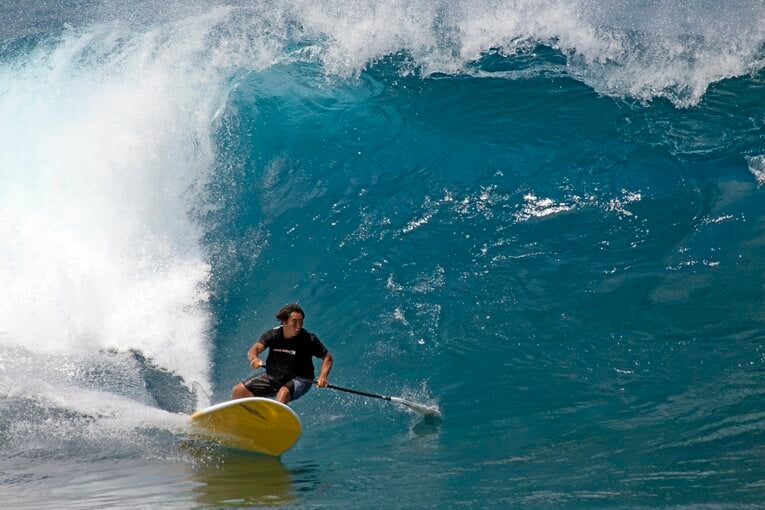 SUPでビッグウェーブに乗るTAKAさん　TAKAさん提供