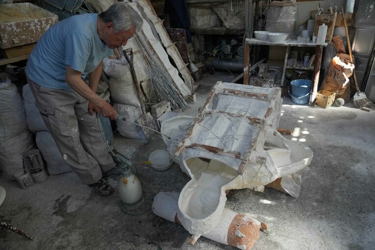5月18日、猪木像の石膏の雌型に離型剤（石鹸水）を吹き付ける石膏師の井野雅文さん