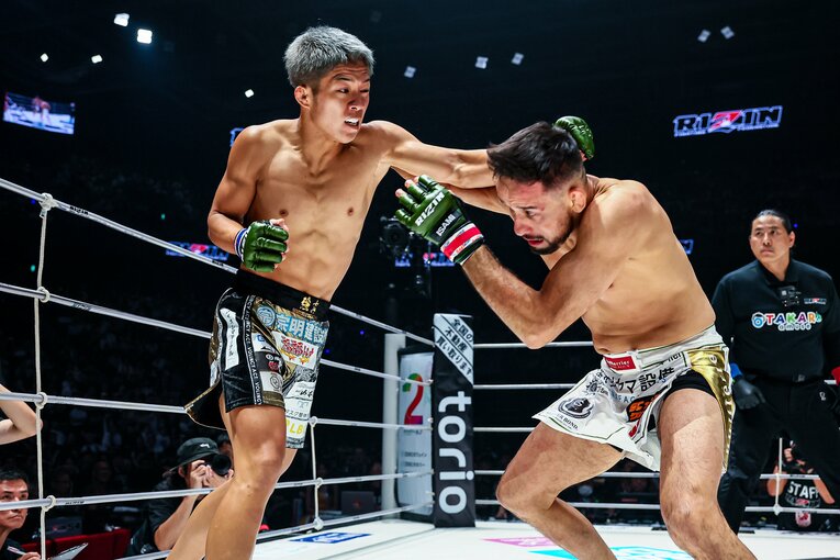打撃を繰り出す秋元と、タックルを狙うクレベル　©RIZIN FF Susumu Nagao