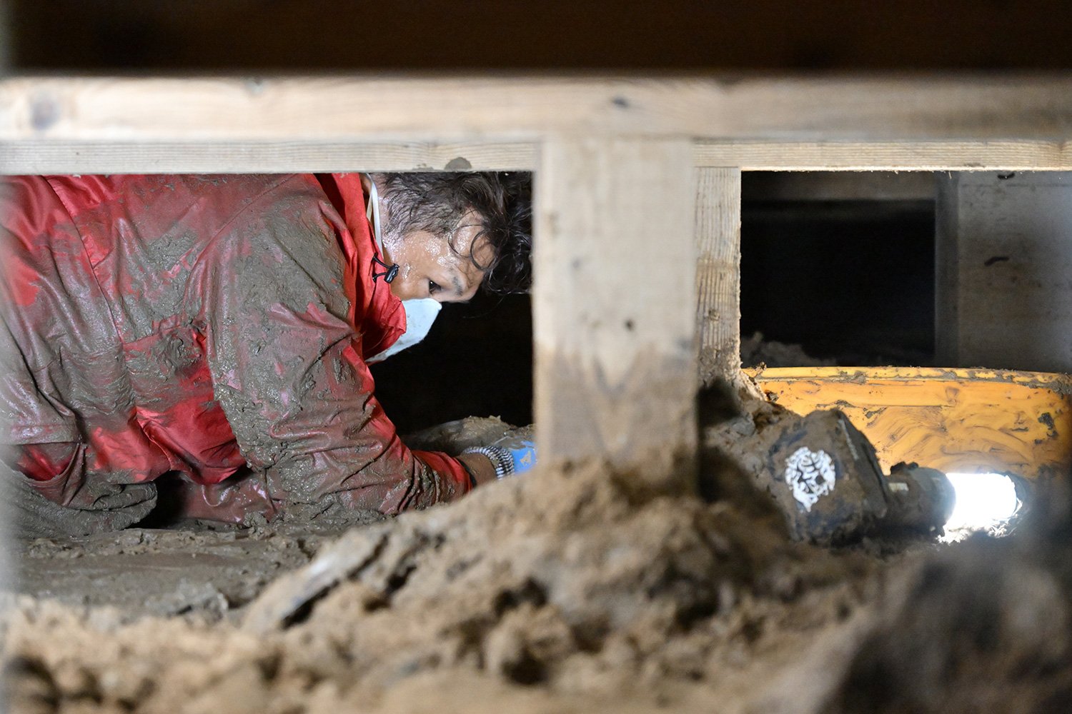 大きな体を屈めて床下の土砂撤去作業に没頭する大西さん