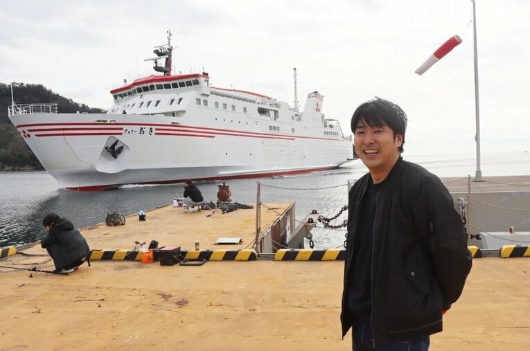 島根県立隠岐高校の野球部監督・渡部謙（34歳）。バックは隠岐諸島と本土（島根県、鳥取県）を結ぶフェリー　©Yuki Kashimoto