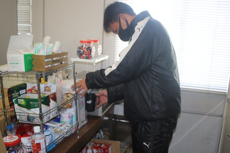 バッグヤードで飲み物を用意するサッカー部員　©︎Takahito Ando