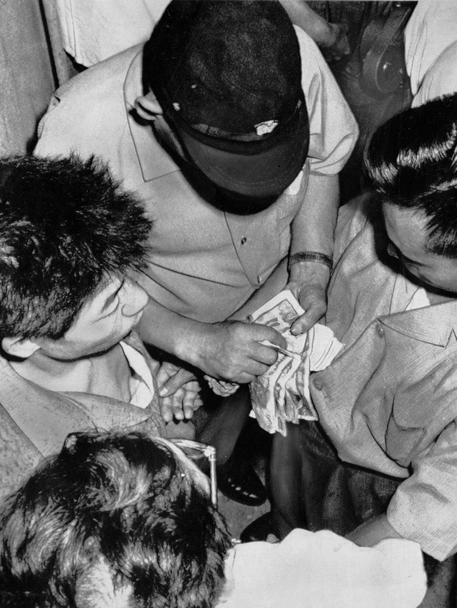 写真は1969年10月、大阪球場での野球賭博の抜き打ち捜査。帽子をかぶって、現金を数えているのが警察官　©Sankei Shimbun