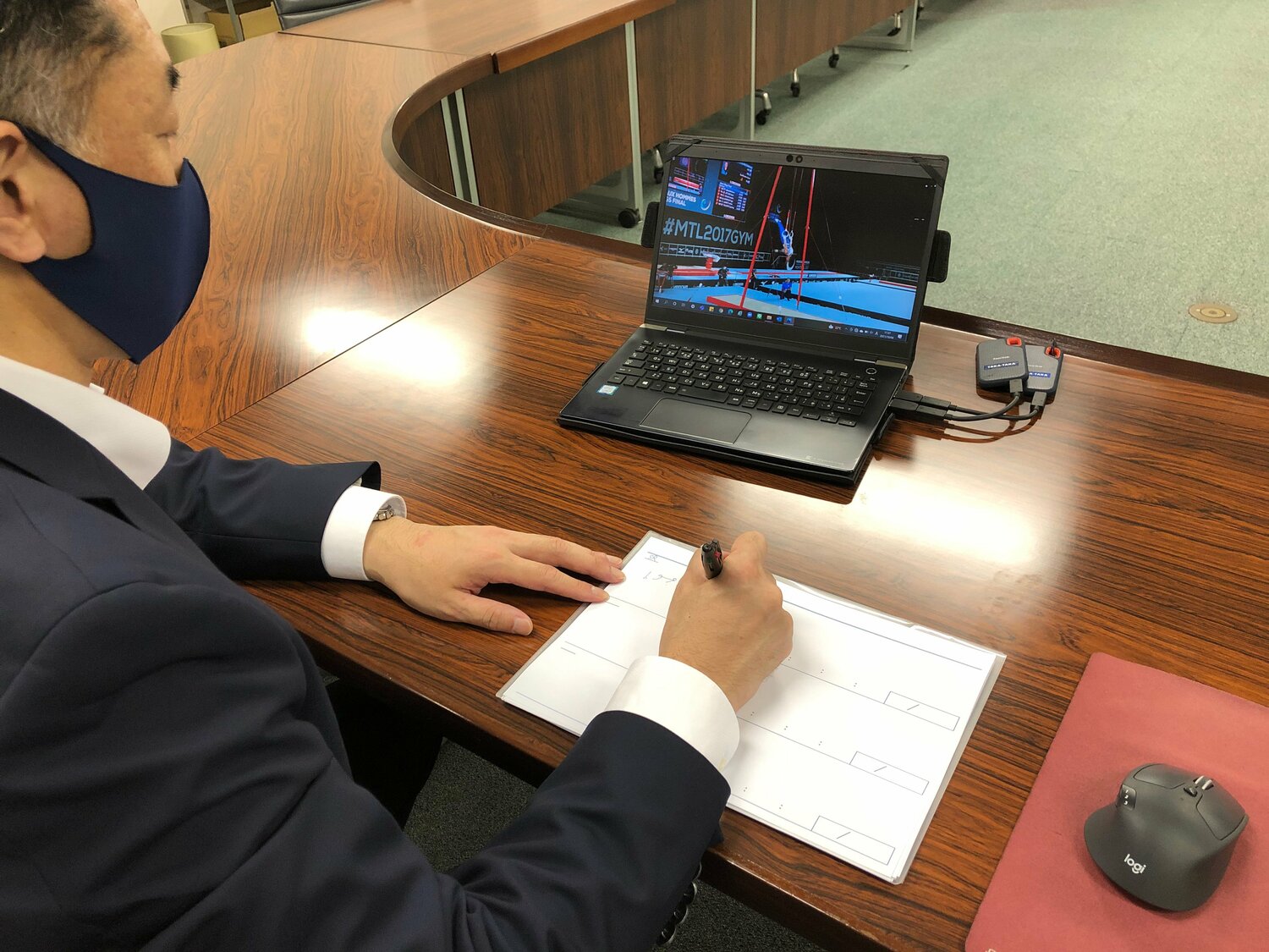 演技映像を見ながら採点作業を実演する高橋氏。画面から視線を外すことなくペンを走らせる　©Sports Graphic Number