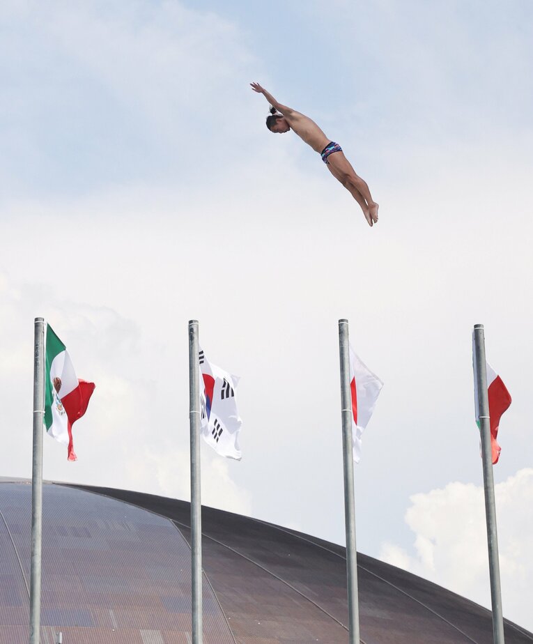 各国の国旗をバックに世界水泳福岡で美しいダイブを見せる荒田　©JIJI PRESS