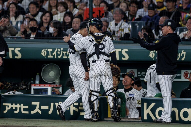 柳田にホームランを打たれた8回を終え、捕手・坂本に迎えられた石井　©Kiichi Matsumoto