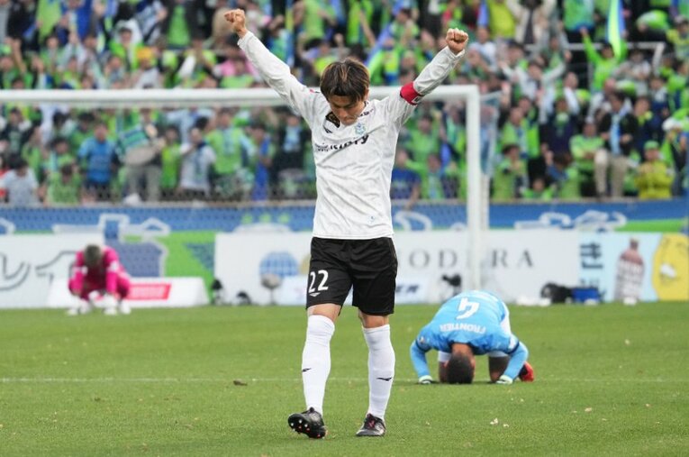 11月25日のJ1第33節。試合終了のホイッスルと同時に拳を突き上げる湘南ベルマーレのキャプテン・大岩一貴と、崩れ落ちる横浜FCの選手たち ／ photograph by Etsuo Hara/Getty Images