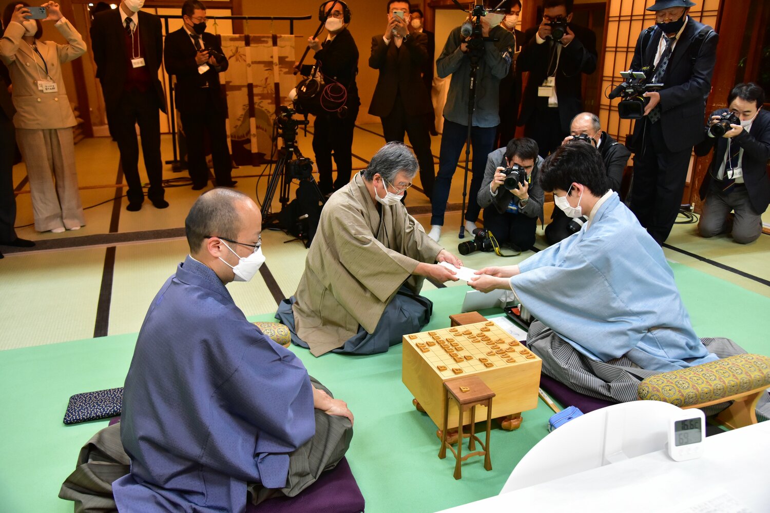 立会人の青野照市九段に封じ手を渡す藤井聡太竜王 ©日本将棋連盟