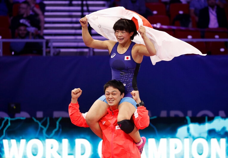 2018年の世界選手権で向田が優勝すると、コーチだった志土地は肩にのせて喜んだ　©AFLO