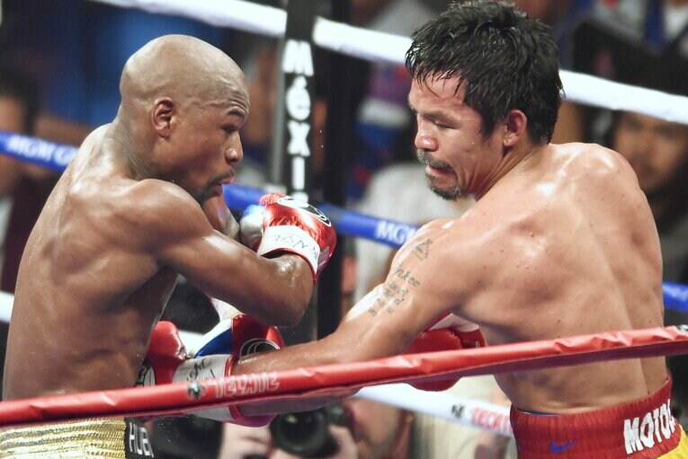 ボディを攻めるパッキャオ。試合は技術に勝るメイウェザーが判定3-0で勝利した