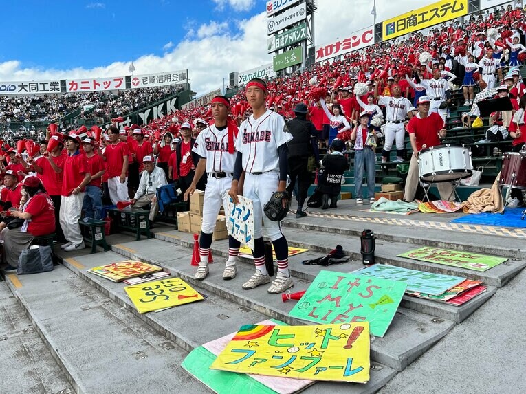 戦況を見ながらカラフルな曲目ボードを掲げる、いなべ総合の野球部　©Yukiko Umetsu