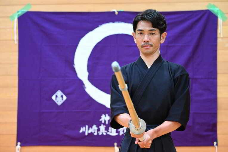 道場旗の前で　©Keiji Ishikawa