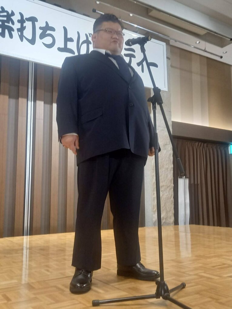 師匠から贈られたスーツであいさつを行った越ノ龍　©Shoko Sato