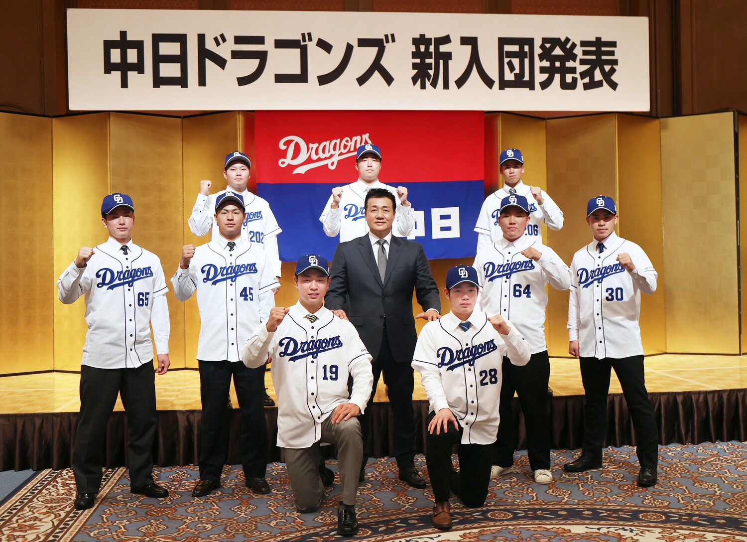 2020年12月、中日の新入団発表会見で、与田剛監督(中央)を囲んでポーズを取るドラフト1位の高橋宏斗投手(前列左)ら新人選手 。後列右が育成指名で入団した松木平だ ©︎JIJI PRESS