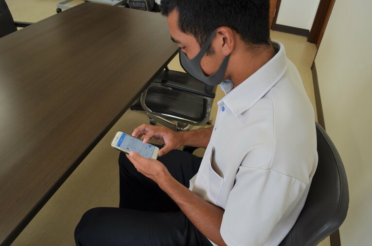 自らがツイートした画面を見つめる西村主将　©︎Toshihide Ishikura