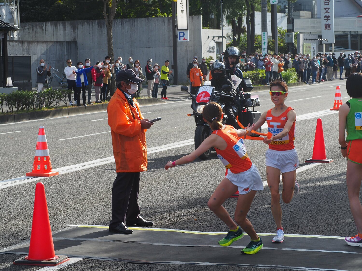 昨年はそのまま駆けていきそうな速さでチームメイトの横からタスキを渡した不破だったが。今年は減速してチームメイトの眼の前でタスキを渡した　©Yu Saito
