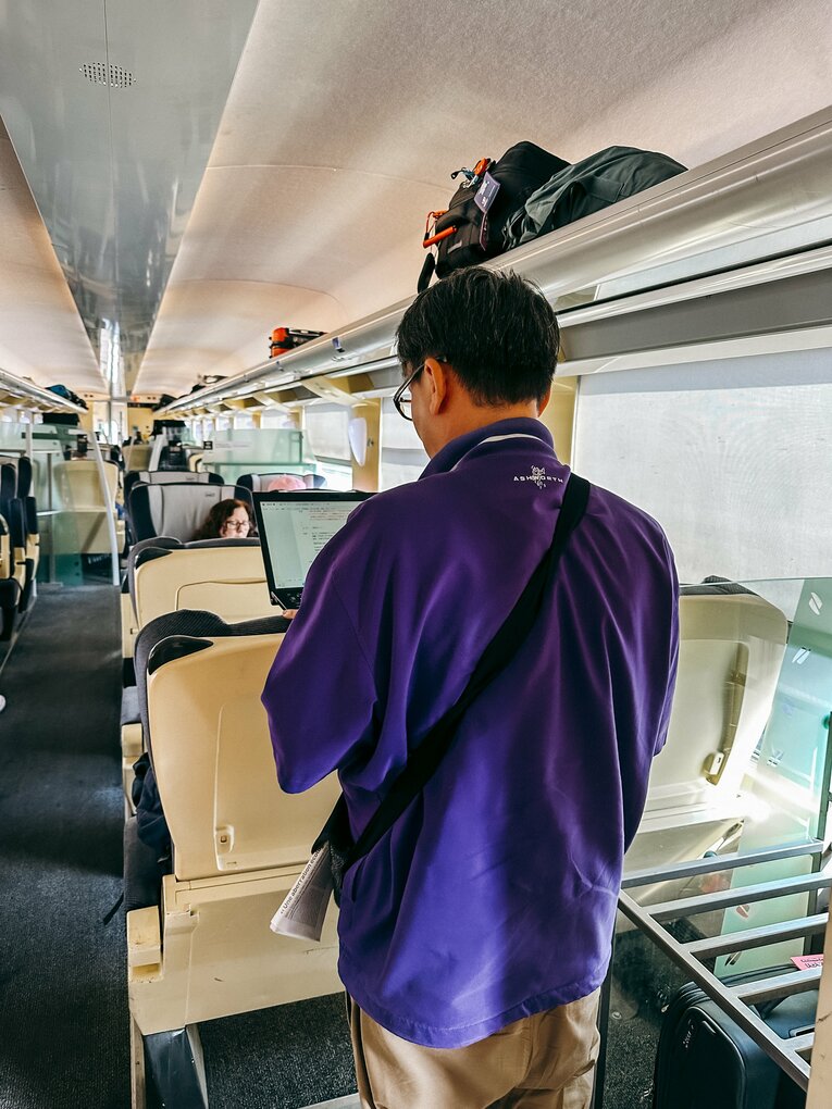 駅から全く動かない特急車内で仕事をする筆者　©Kiichi Matsumoto