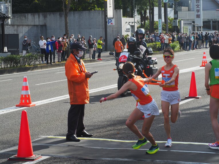昨年はそのまま駆けていきそうな速さでチームメイトの横からタスキを渡した不破だったが。今年は減速してチームメイトの眼の前でタスキを渡した　©Yu Saito