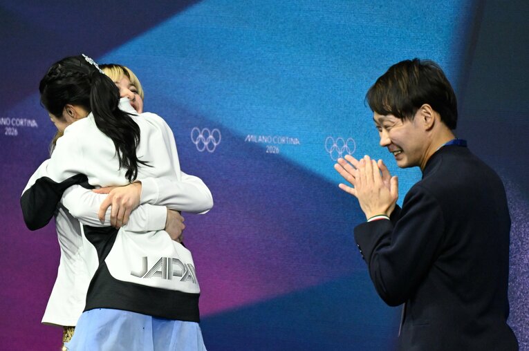 銅メダルとわかり、祝福してくれたアリサ・リュウに飛びつく中井亜美。そんな様子を中庭コーチは微笑ましく見守っていた（2026年ミラノ・コルティナ五輪）　©︎Asami Enomoto/JMPA