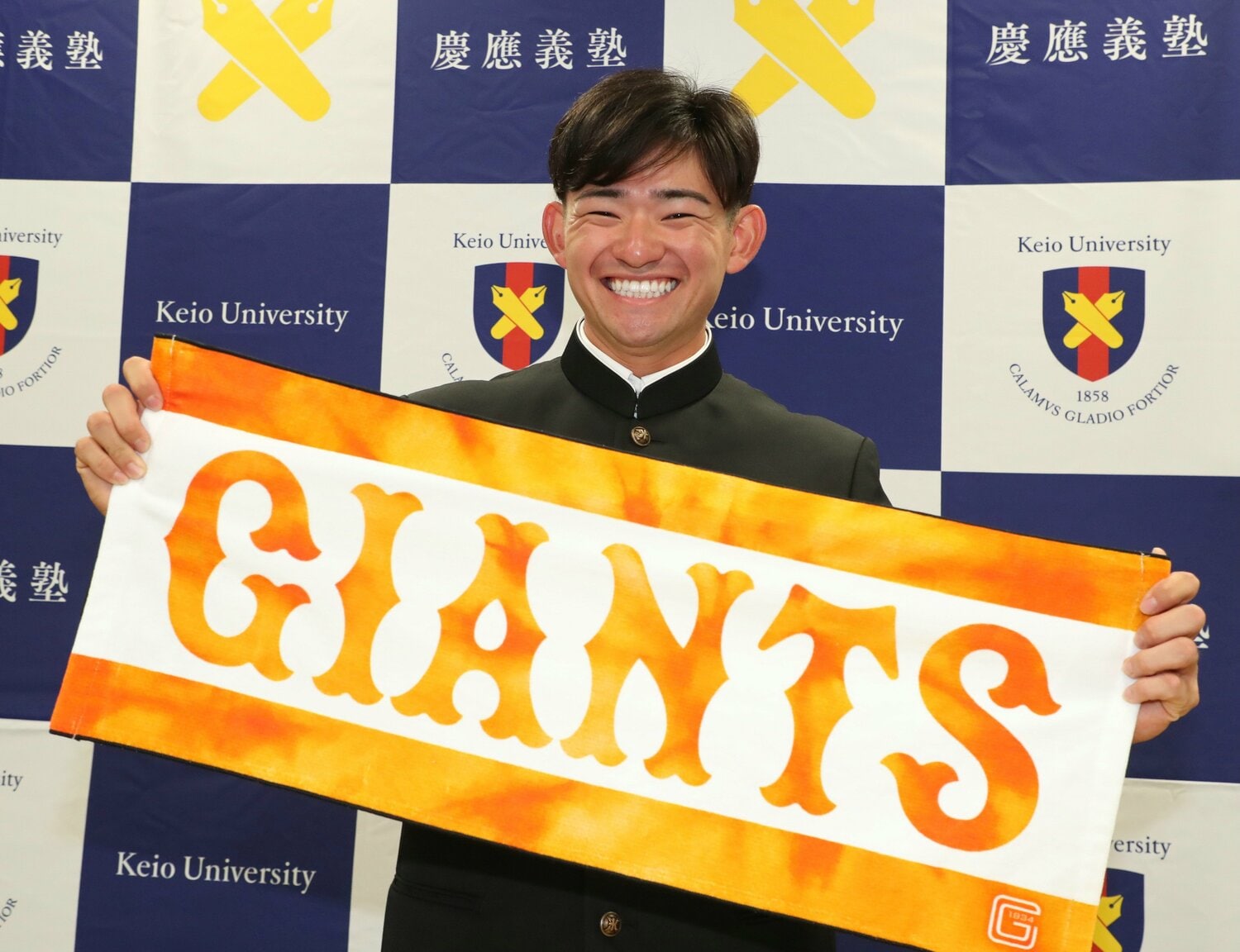 巨人から2位で指名を受け、笑顔を見せる慶応大の萩尾匡也外野手　©JIJI PRESS