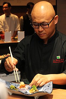 真剣な面持ちで仕上げに取り組む岡元シェフ。皿の上は、まるで美しい絵画のように、料理によって見事に彩られた。