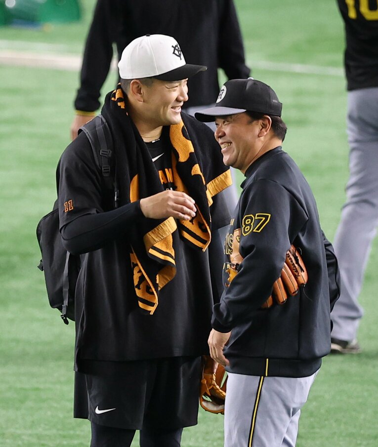 4月4日、阪神・野村克則コーチと談笑する田中将大。田中が楽天に入団した2007年から、野村は二軍育成コーチに就任し、3年間、同じチームに所属していた　©Sankei Shimbun