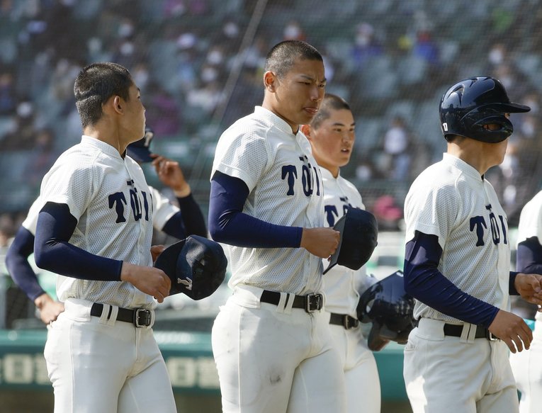 センバツで初戦敗退を喫し、苦い表情でベンチへ引き上げる先発・松浦　©︎KYODO