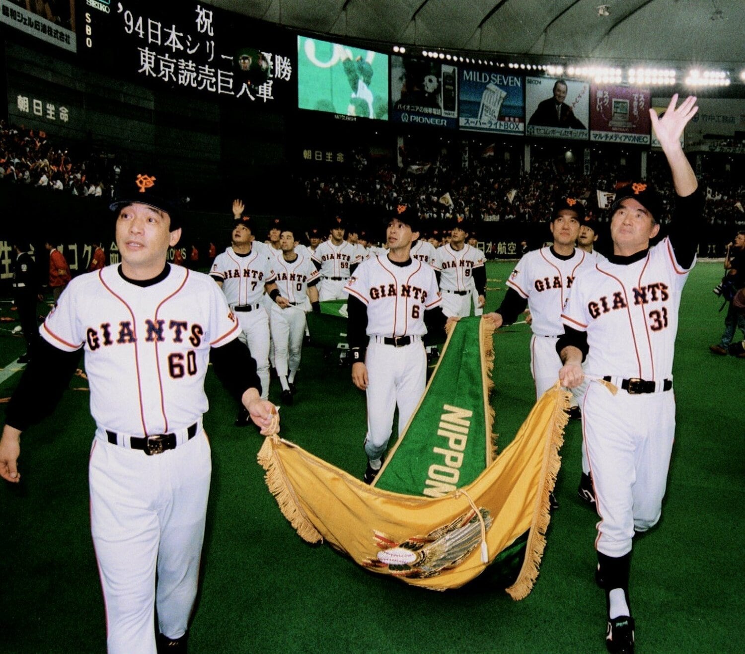 1994年10月29日、日本シリーズ第6戦に勝ち、5年ぶり日本一に輝いた巨人。ケガの落合（左）、長嶋監督を先頭に、優勝旗を手にグラウンドを一周する　©KYODO