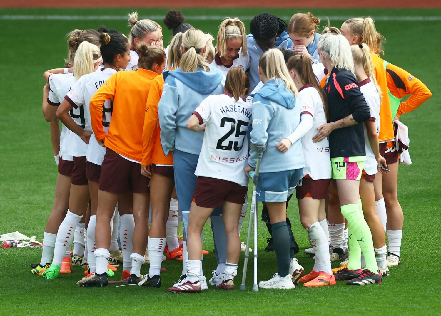 チームメイトに囲まれると小柄な身長が際立つ（長谷川は25番）©︎Reuters/AFLO