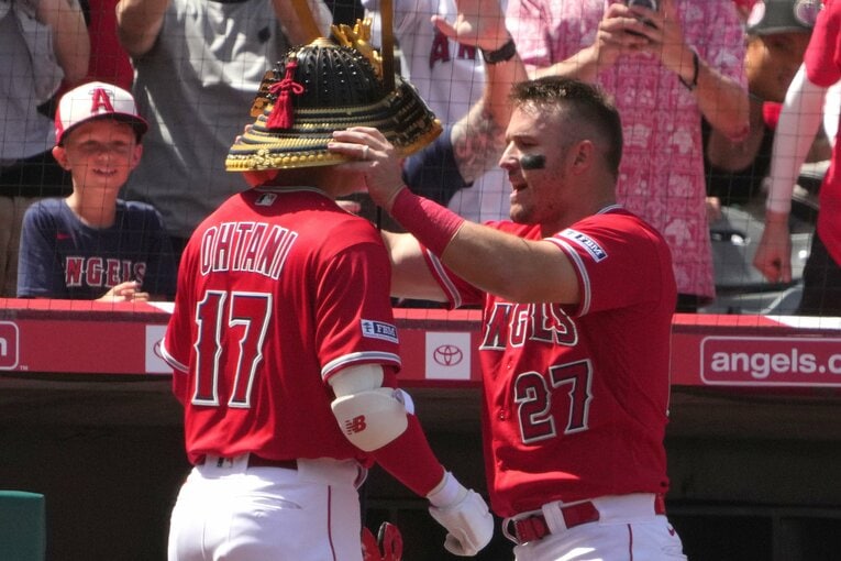 トラウタニの兜パフォに観客も興味津々、トラウトは武士のようにマジメな表情で兜を着せる　©JIJI PRESS