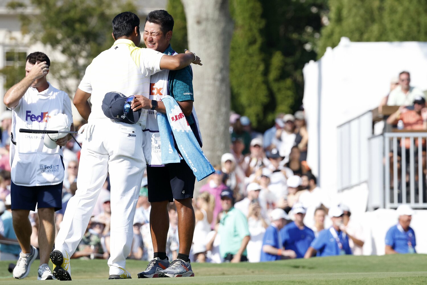 松山にハグされ、安堵の表情を浮かべる田淵キャディ ©︎Getty Images