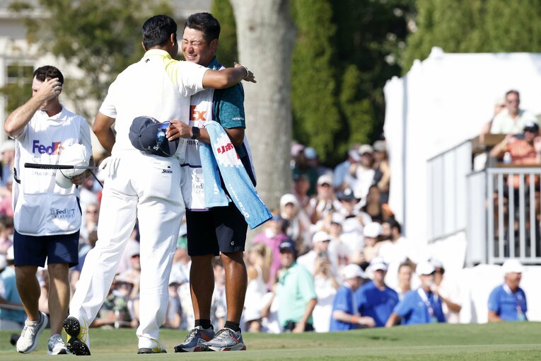 松山にハグされ、安堵の表情を浮かべる田淵キャディ　©︎Getty Images