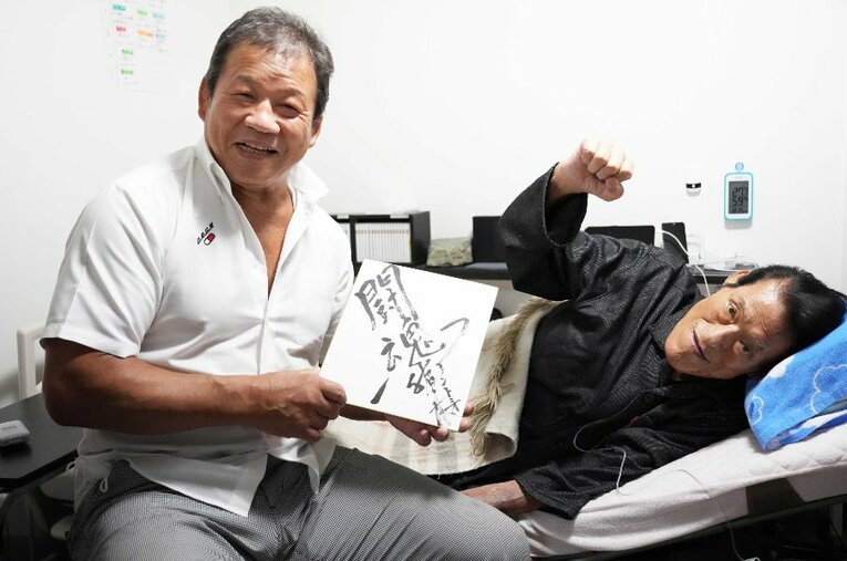 2022年7月29日、故・アントニオ猪木さんと藤波辰爾が最後に会った日。筆書きのサインを手に記念撮影を行った ／ photograph by Essei Hara