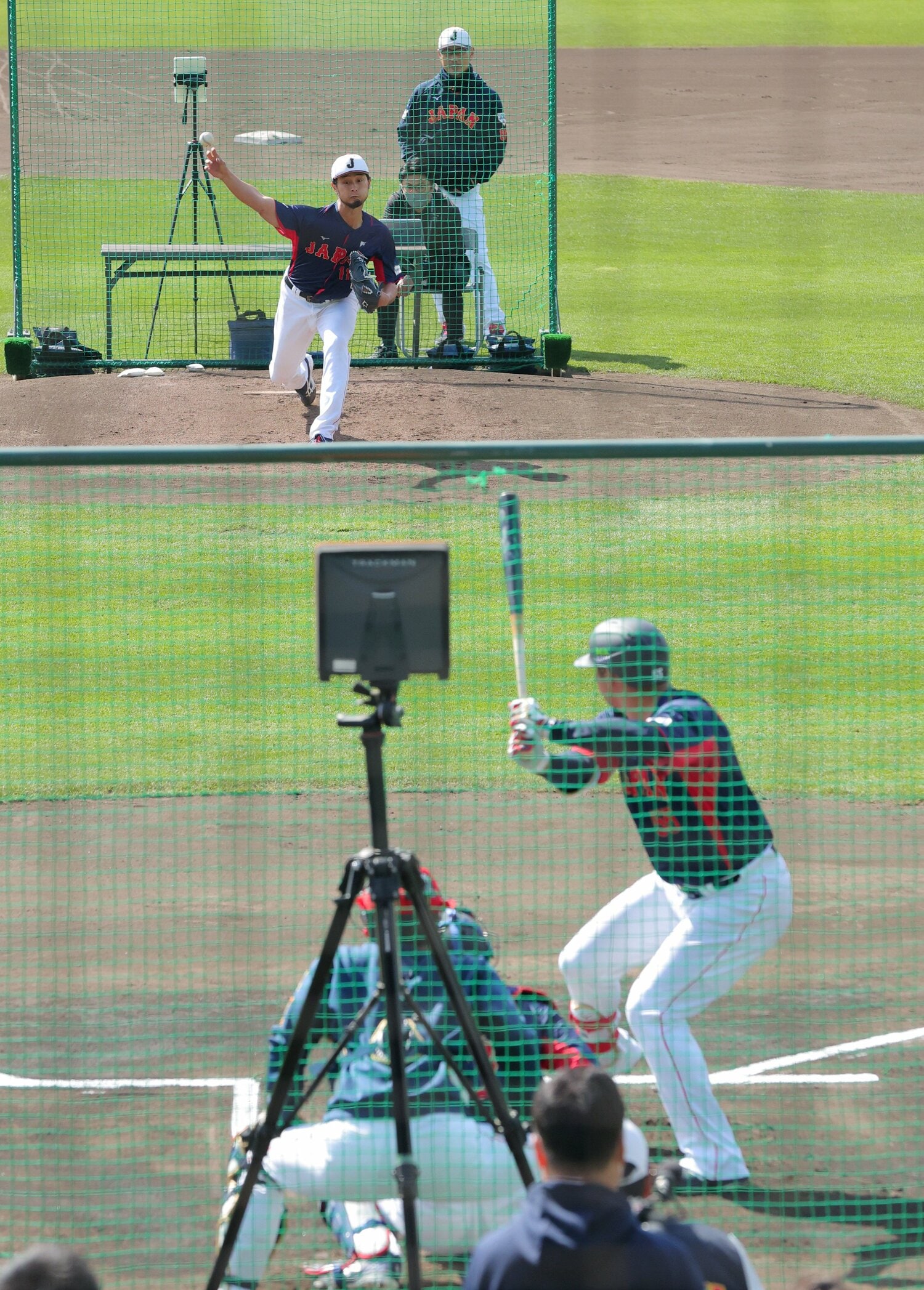 WBC開幕前の強化合宿、データ計測器の前で、村上宗隆相手にピッチングするダルビッシュ　©JIJI PRESS