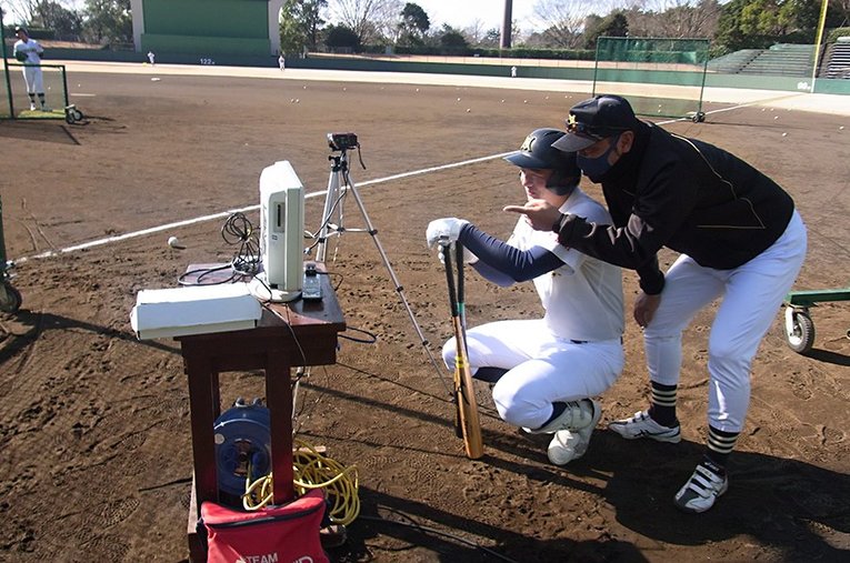 バッティング練習の動画をチェックする監督と選手。三島南の取り組みは“普通の学校”にも参考になるかもしれない ／ photograph by Jun Takagi