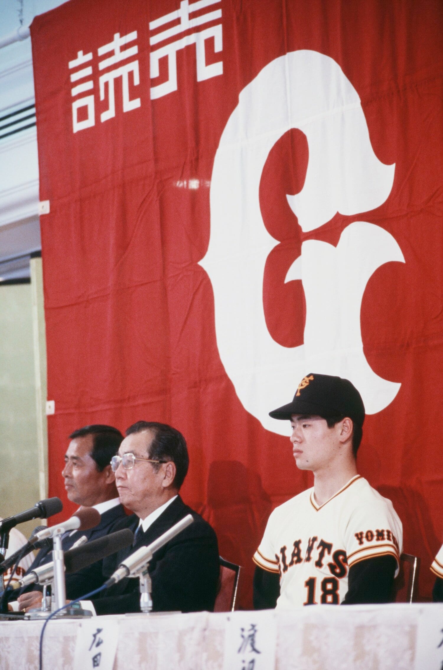 入団会見に臨む17歳の桑田真澄（右）。左に正力亨オーナー、奥に王貞治監督　©JIJI PRESS