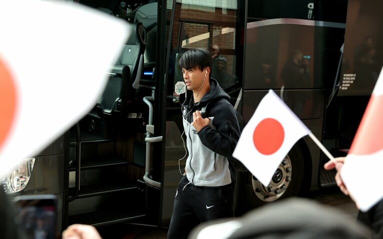 写真は三笘がクラブバスから現れた場面。ファンが日の丸をふる　©Getty Images
