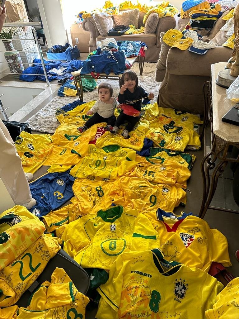 保有しているブラジル代表の各選手サイン入りユニフォームと、孫娘2人　※本人提供