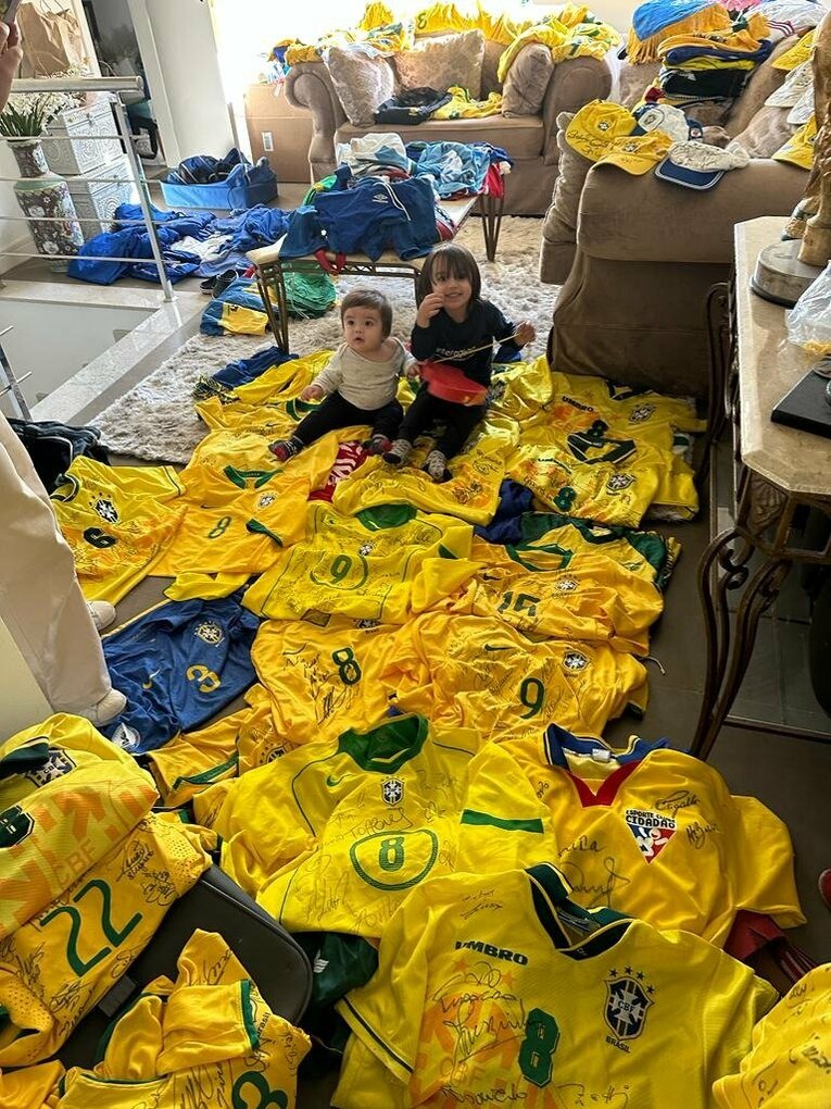 保有しているブラジル代表の各選手サイン入りユニフォームと、孫娘2人　※本人提供