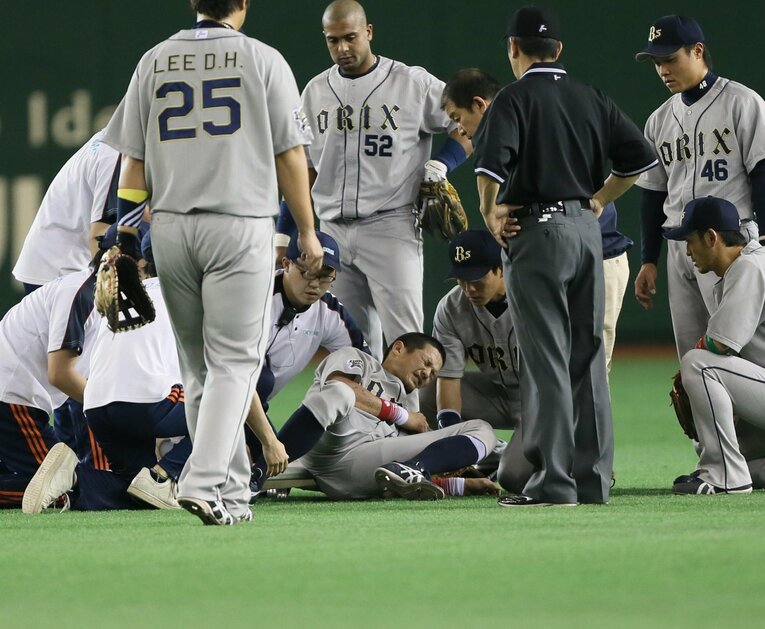 巨人戦でダイビングキャッチをした後、痛みのあまり動けず顔を歪める坂口（中央）　©︎SANKEI SHIMBUN
