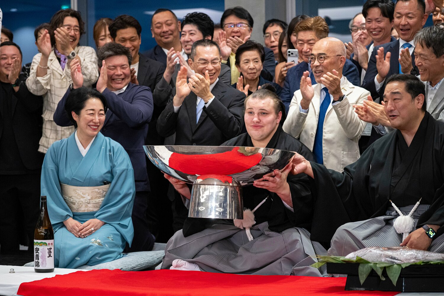 優勝後、祝杯を手に笑顔の安青錦（中央）と安治川親方（右）　©Takuya Sugiyama